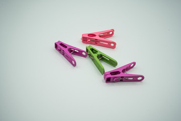 Many colored clothes pegs and many white backgrounds