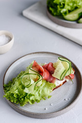 Sandwich with cream cheese, salmon, cucumber and lettuce. Morning and Breakfast. Healthy nutrition. Selective focus