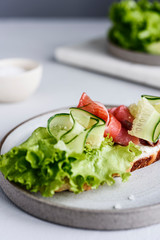 Sandwich with cream cheese, salmon, cucumber and lettuce. Morning and Breakfast. Healthy nutrition. Selective focus