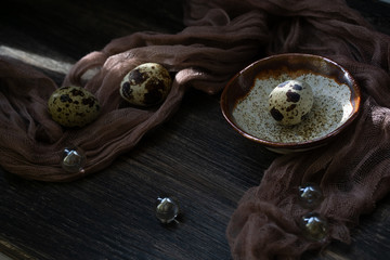 Quail eggs on a wooden dark surface