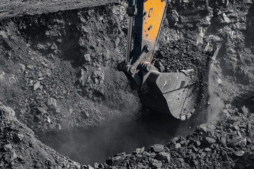 Yellow excavator works and extracts coal from bowels of earth. Open pit mine industry