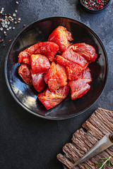 raw meat pork or beef in a plate on the table (preparing healthy food, marinade and spices paprika) menu concept background. top view. copy space for text