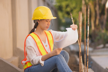 Working women holding blueprint paperwork document  standing at building construction,She is...