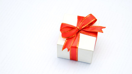White gift box with red ribbons isolated on white background
