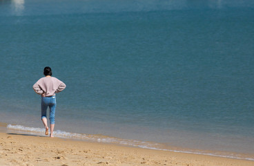 海の砂浜で遊んでいる綺麗な若い女性