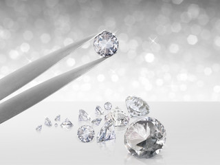 Diamond in tweezers on white shining bokeh background. concept for chossing best diamond gem design