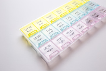 Organizer for medical pills on a white isolated background close-up. Organization of taking pills of the day.