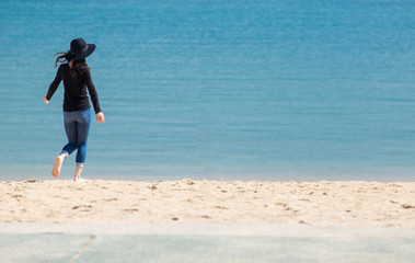 海の砂浜で遊んでいる綺麗な若い女性