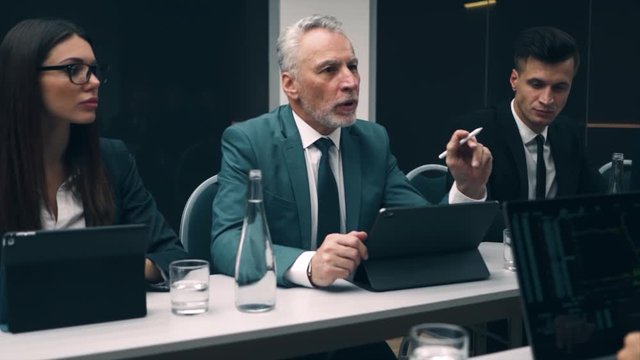 The old businessman talks to his team. slow motion