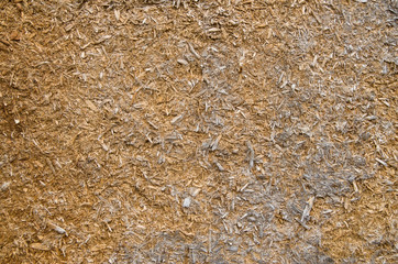 Old crumbling particle board on wall closeup