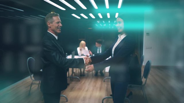 The businessman and businesswoman handshaking in the meeting room. slow motion