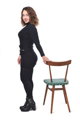 portrait of a woman standing with chair in white background,looking at camera