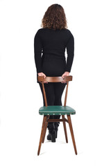 Fototapeta premium rear view of woman standing on a chair in white background