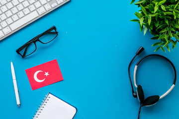 Learn Turkish online. Concept with flag, headset and keyboard on blue background top-down copy space
