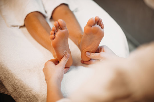 Close up photo of a spa professional having a feet massage session at the salon