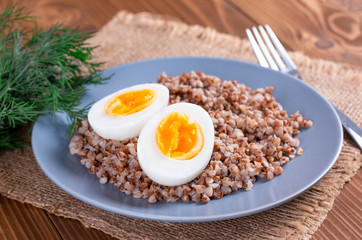 Boiled eggs and buckwheat on wooden table