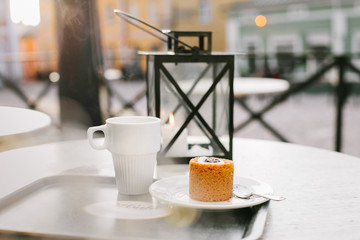 cup of coffee and traditional dessert on wooden table on the street in Europe village Porvoo Finland
