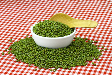 mung beans in ceramic bowl and wooden spoon with table cloth pattern scotch white red colour  