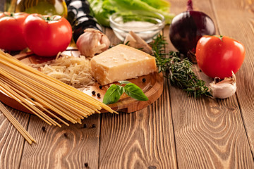 Ingredients for spaghetti bolognese with cherry tomatoes and basil on a wooden table