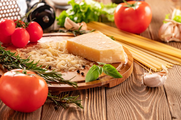 Ingredients for spaghetti bolognese with cherry tomatoes and basil on a wooden table