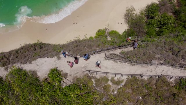 Indonesia Aerial Kelingking Beach Nusa Penida. Vertical View Tourists on Cliff/descent