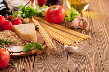 Ingredients for spaghetti bolognese with cherry tomatoes and basil on a wooden table