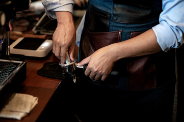 Barista make coffee with espresso machine in cafe. Barista male hands make fresh coffee close-up. Coffee machine and hands professional barista.