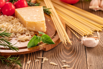 Ingredients for spaghetti bolognese with cherry tomatoes and basil on a wooden table