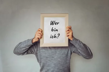 "Wer bin ich?" - Konzept für Marketing, Zielgruppen, Buyer Persona - Geschäftsmann bedeckt sein Gesicht mit einem Bilderrahmen © tomfallen