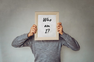 "Who am I?" - Konzept für Marketing, Zielgruppen, Buyer Persona - Geschäftsmann bedeckt sein Gesicht mit einem Bilderrahmen