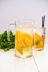 lemonade with citrus in a decanter. on white background. cocktail.