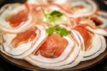 Slide raw pork with fat lines stacked on plate for shabu, BBQ or grill.