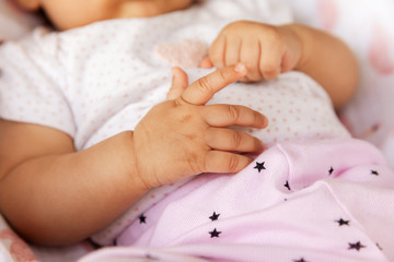 Baby girl with tiny arms laying and relaxing in the summer, maternity and babyhood concept