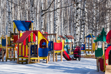 Wooden colored Playground for children in birch Park in winter