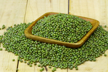 mung beans in wooden bowl on wooden table top