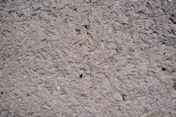 Rough weathered surface of mud daub on a wall