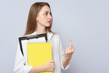Naklejka premium Young student woman showing middle finger, grey background, copy space