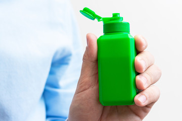 Person shows green medical bottle, woman's hand, closeup, cropped image, copy space