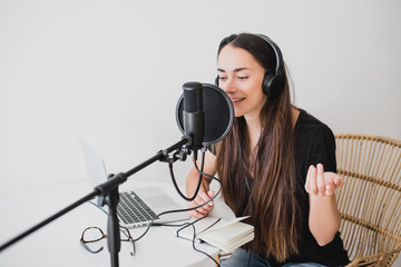 Woman blogger recording radio podcast in studio. - obrazy, fototapety, plakaty