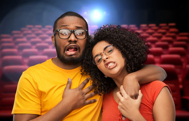 Obraz premium cinema, entertainment and people concept - african american couple over movie theatre background