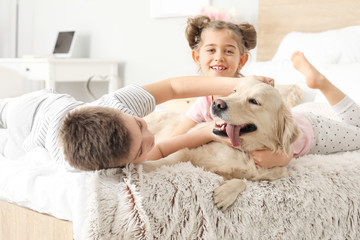 Happy children with dog in bedroom at home