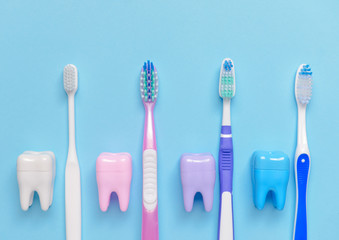 Tooth brushes and plastic teeth on color background