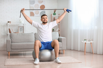 Sporty young man training at home