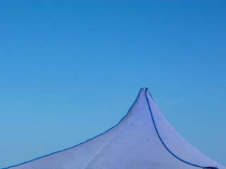 Tip of a tent over the sky
