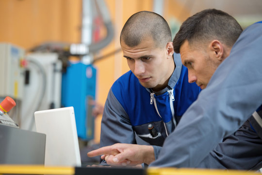 two wood designer working with laptop in workshop