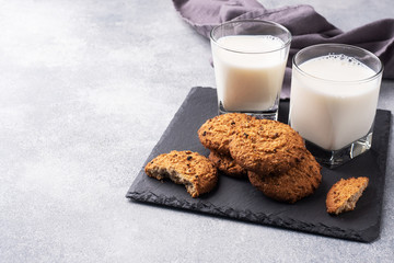Homemade cookies cereals oats and a glass of milk on the grey concrete table. Copy space.