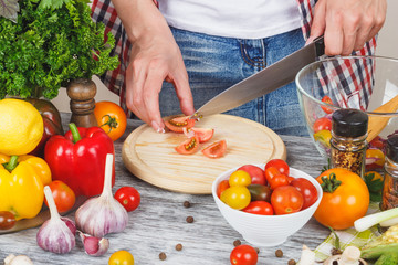Woman cooks at the kitchen, body part