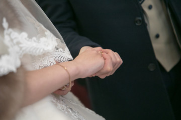 Young married couple holding hands, ceremony wedding day