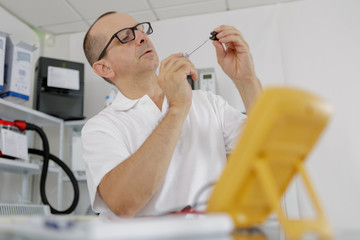 electrician checking socket voltage using multimeter