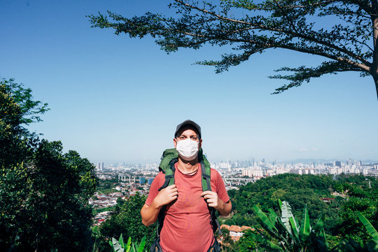 Man with mask and backpack outdoors